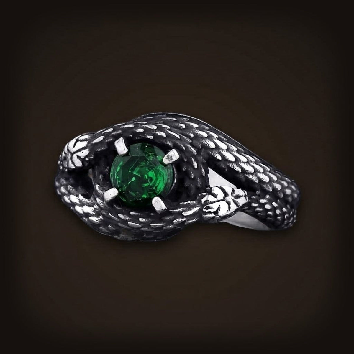 Bague en acier noirci, deux serpents aux écailles polies enlacés autour d'une pierre facettée (verte)