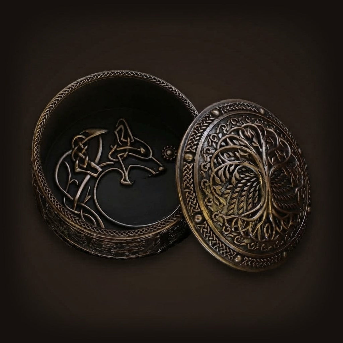 Boîte à bijoux viking ouverte en résine bronze montrant l'arbre Yggdrasil sur le couvercle et un loup en entrelacs sculpté au fond du coffret.