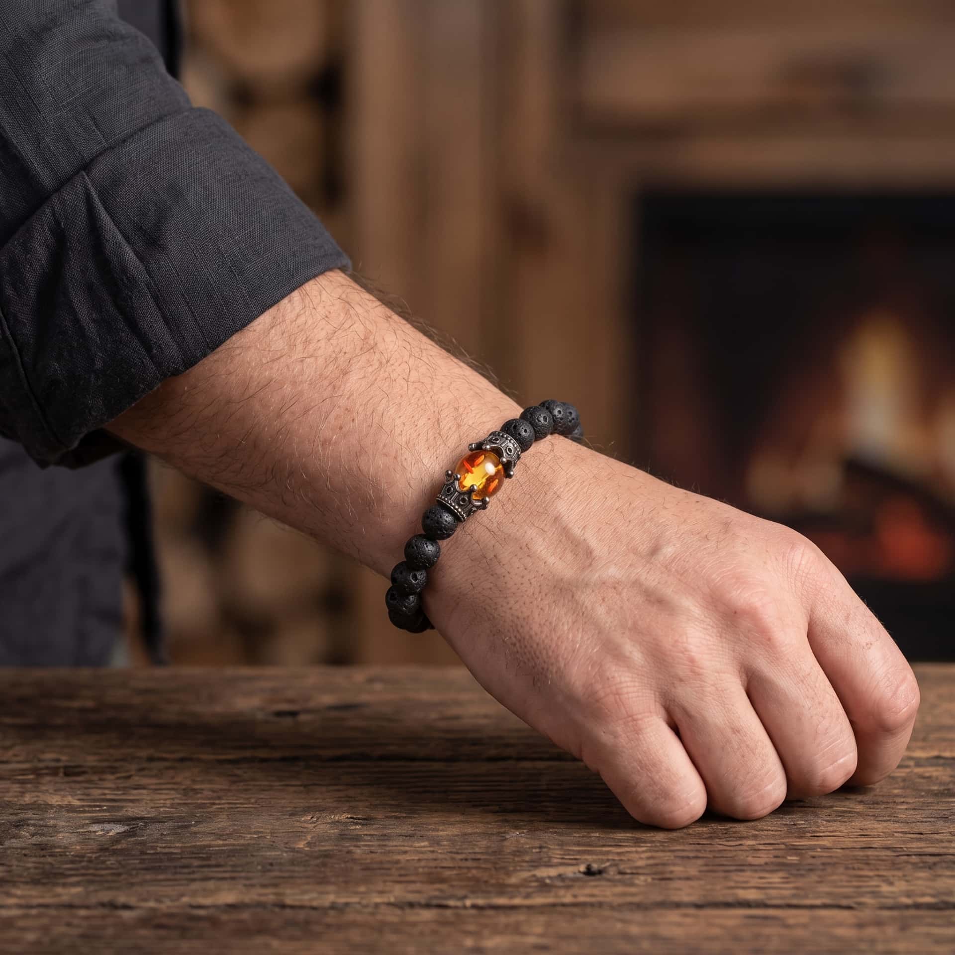 Bracelet de Perles en Pierre de Lave Noire : Couronnes et Perle de Feu, porté au poignet
