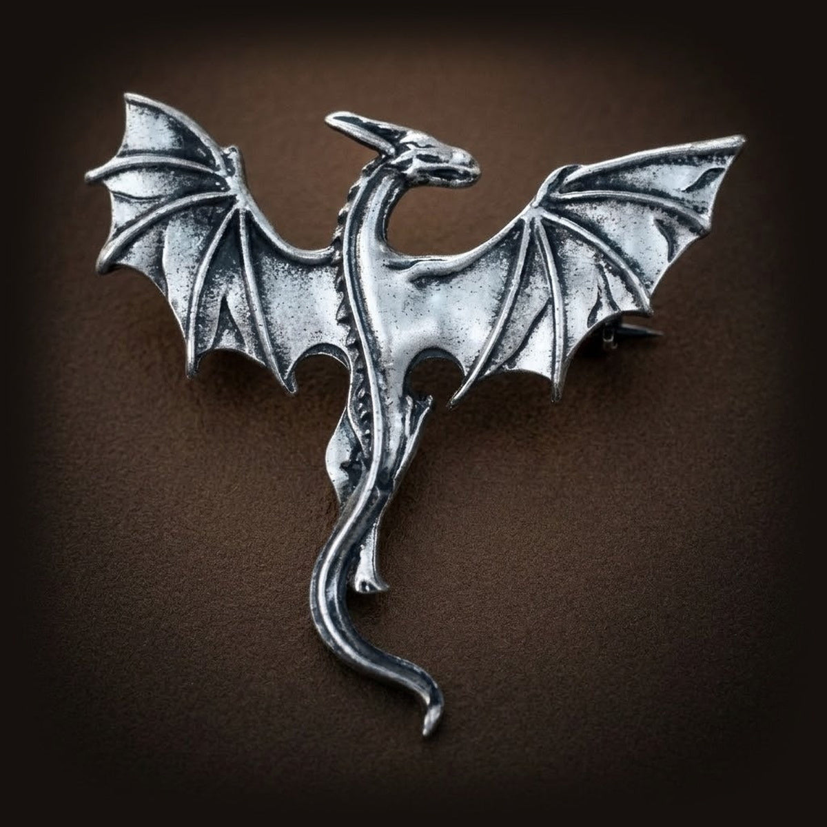 Broche viking dragon en vol, alliage argenté, ailes nervurées déployées et queue effilée