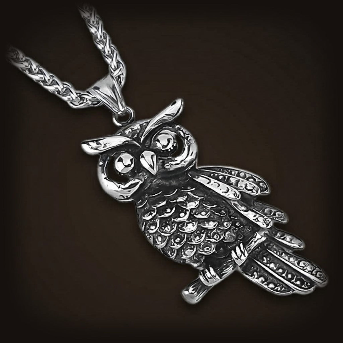 Pendentif hibou en acier inoxydable, plumage détaillé et grands yeux ronds, sur sa chaîne tressée