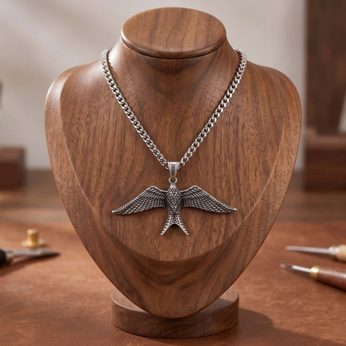 Collier Pendentif Hirondelle : Acier 316L, Chaîne Serpent, pendentif présenté sur un buste de bois