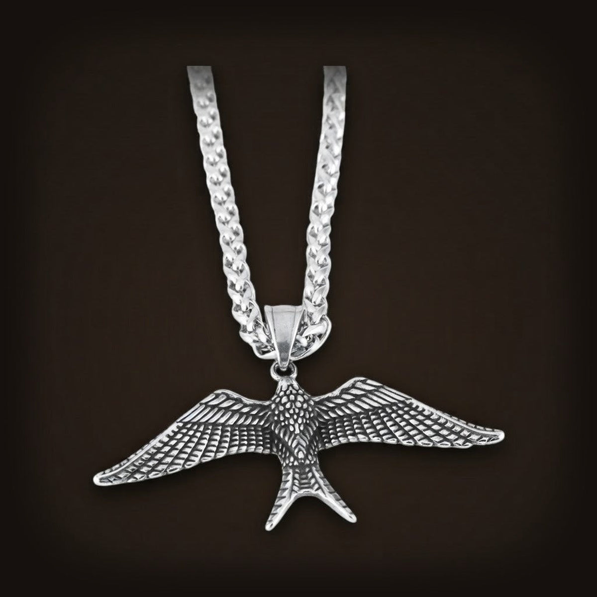 Collier Pendentif Hirondelle en acier 316L : hirondelle aux ailes déployées et aux plumes gravées, sur sa chaîne