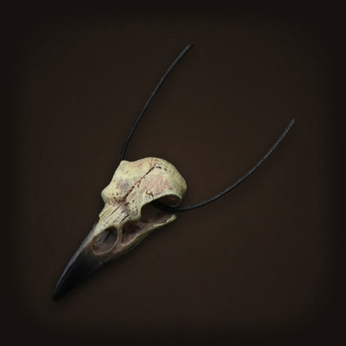 Collier viking, crâne de corbeau en résine imitation os à patine vert-de-gris, bec noir, sur cordon de cuir