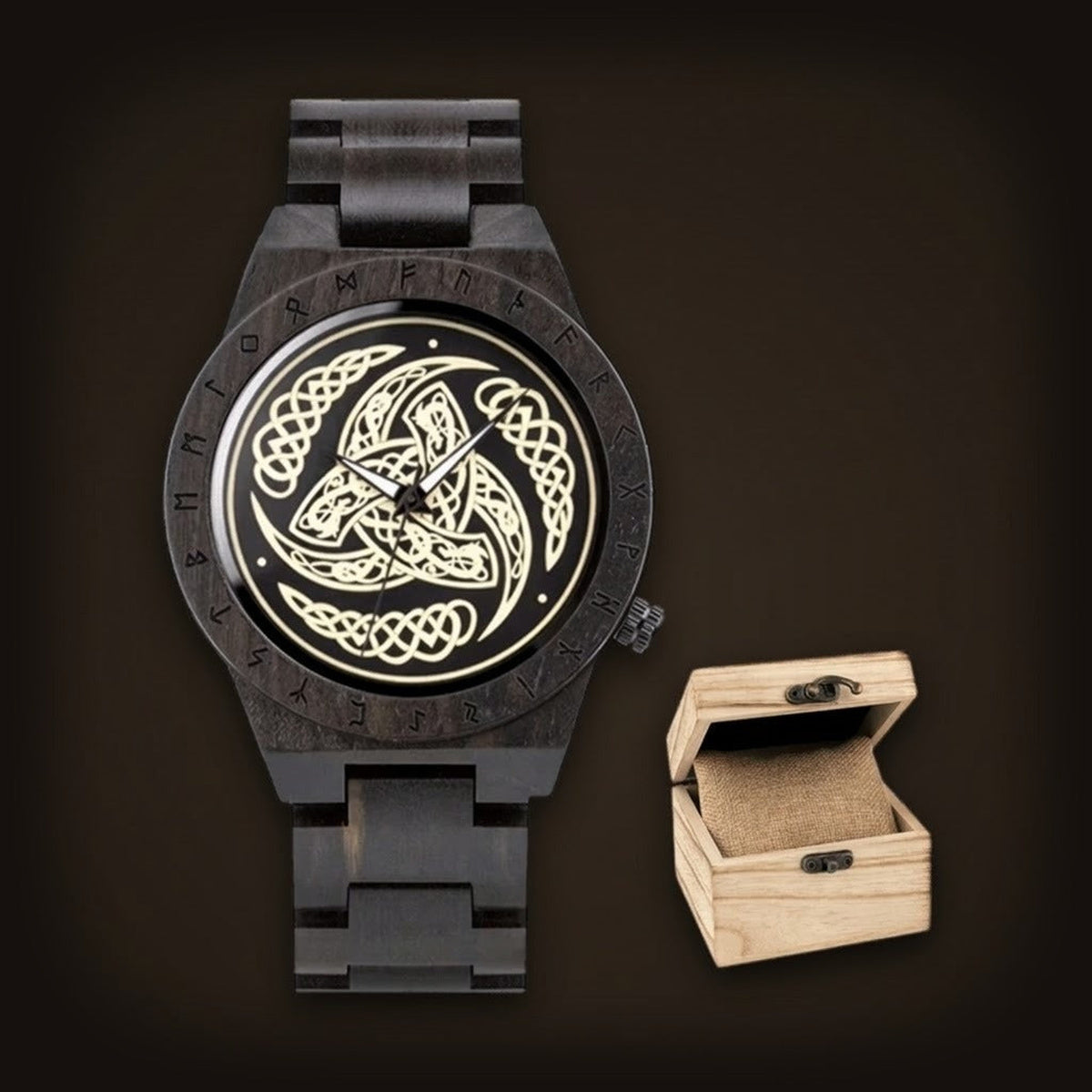 Montre viking pour homme en bois noir avec lunette gravée de runes et cadran à triskèle celtique doré, à côté de sa boîte en bois.