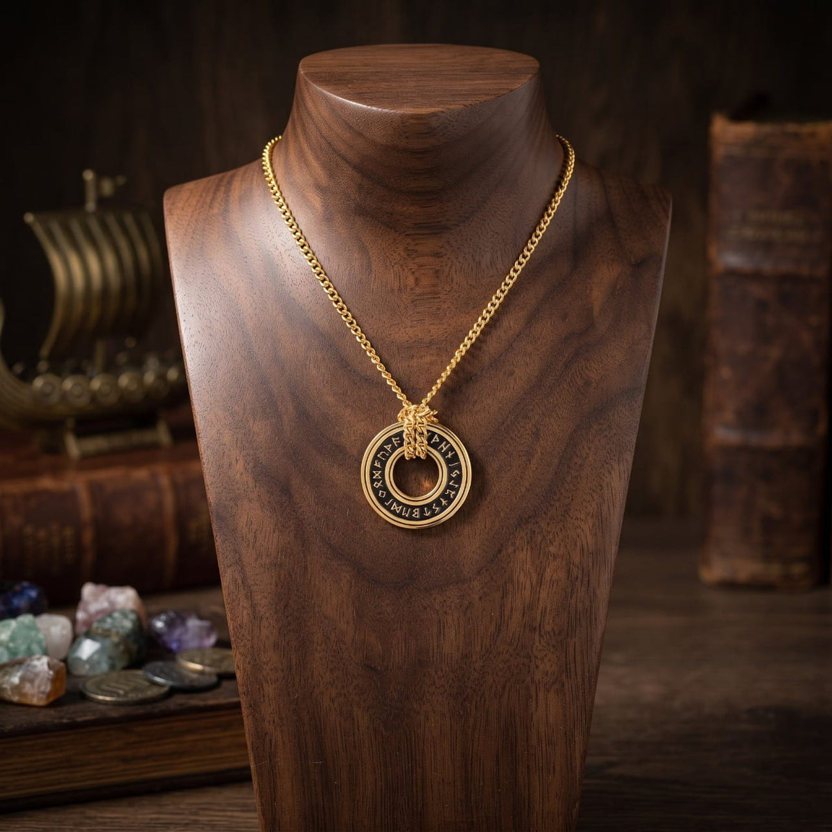 Pendentif anneau runique doré sur chaîne dorée, présenté sur un buste de bois