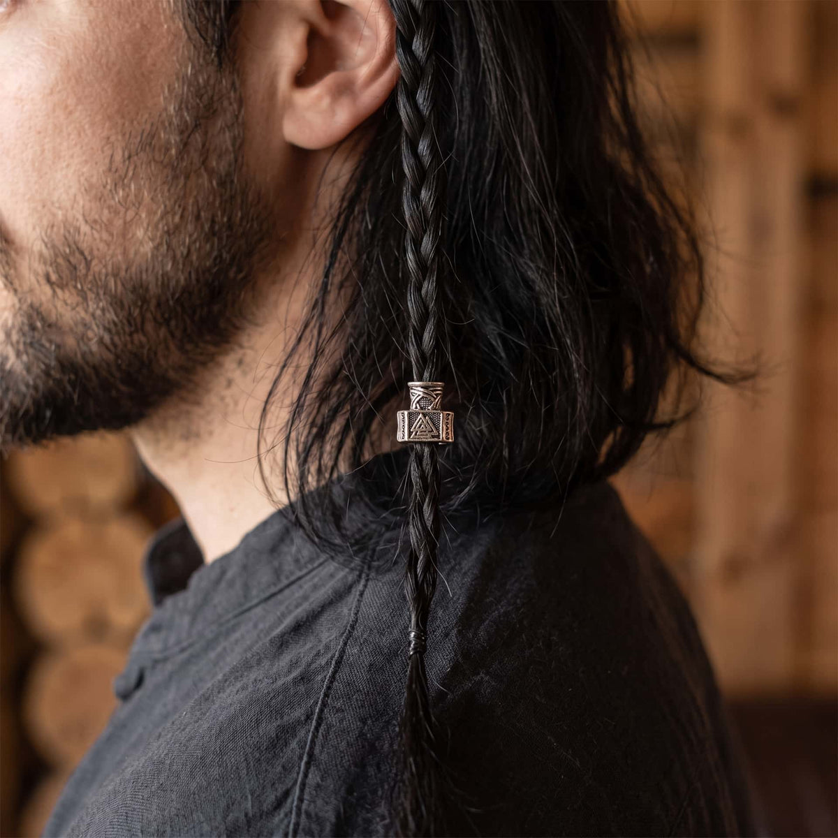 Perle viking en alliage argent vieilli, en forme de marteau de Thor, la face gravée d'un Valknut, portée sur une fine tresse de cheveux