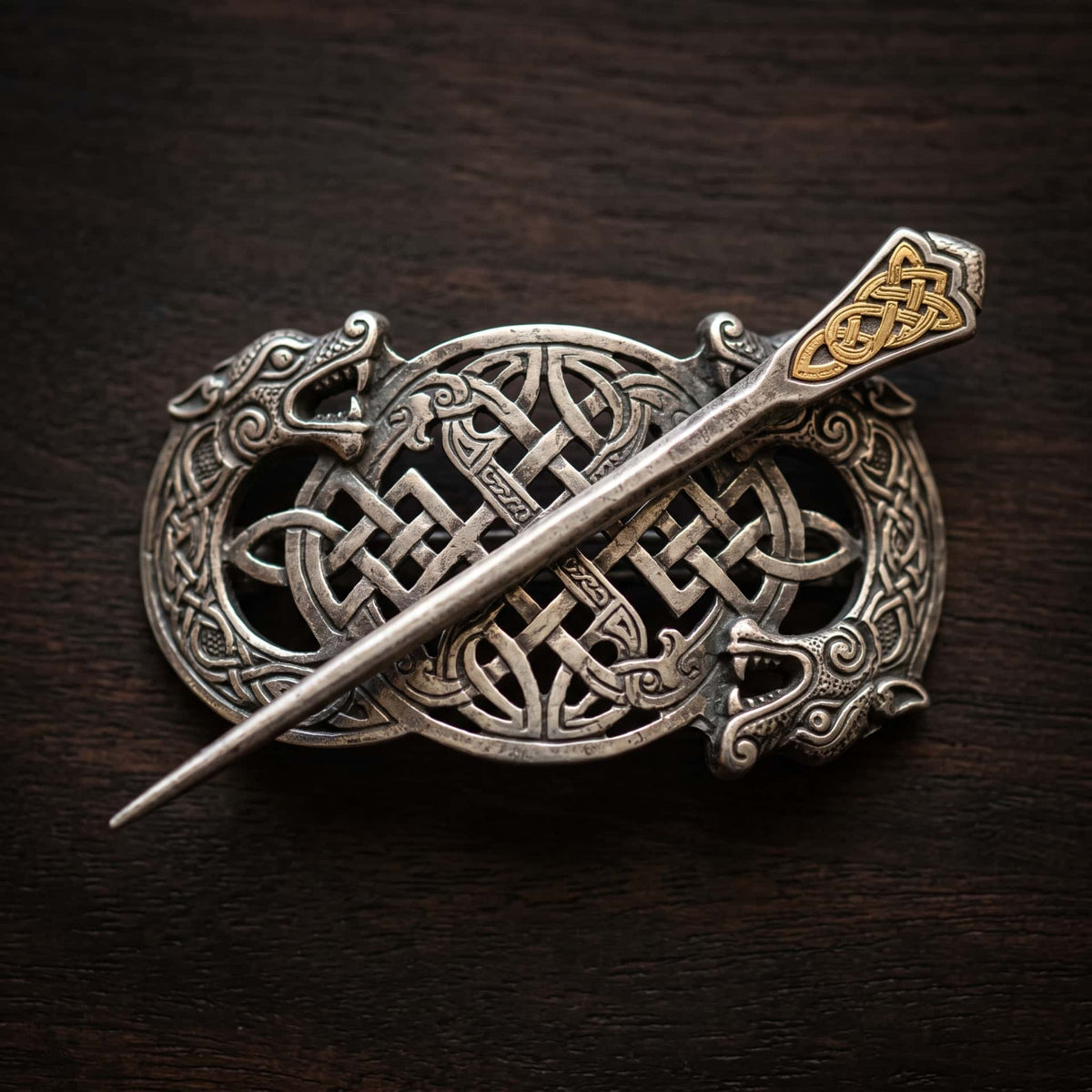 Barrette viking en argent ajourée d'entrelacs celtiques et de têtes de dragon, longue pique traversante à tête gravée d'or