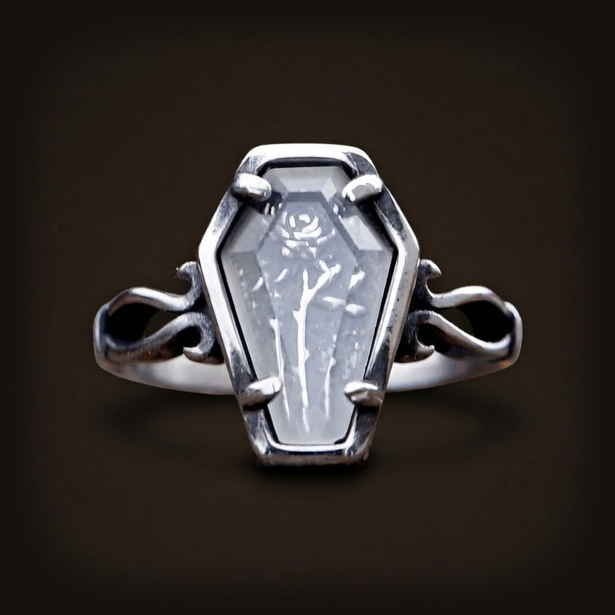 Bague en acier, plateau en forme de cercueil avec rose en relief sous verre et épaules en volutes ajourées