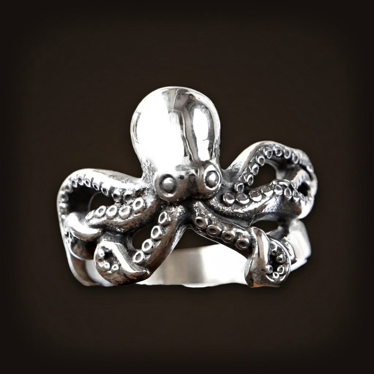 Bague en acier sculptée en forme de pieuvre, tête bombée et tentacules à ventouses formant l'anneau