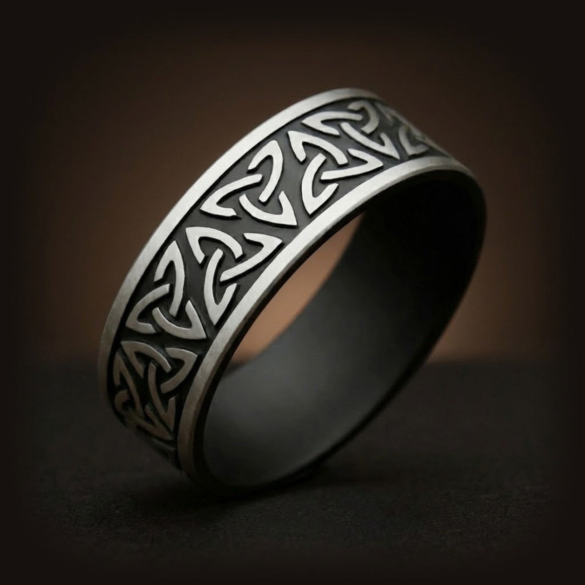 Bague viking de type anneau en acier inoxydable avec gravures répétées du symbole Triquetra en finition antique.
