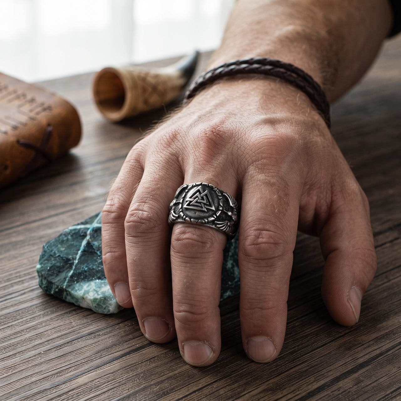 Bague chevalière en acier au Valknut encadré d'un corbeau aux ailes déployées, portée à l'annulaire d'une main d'homme