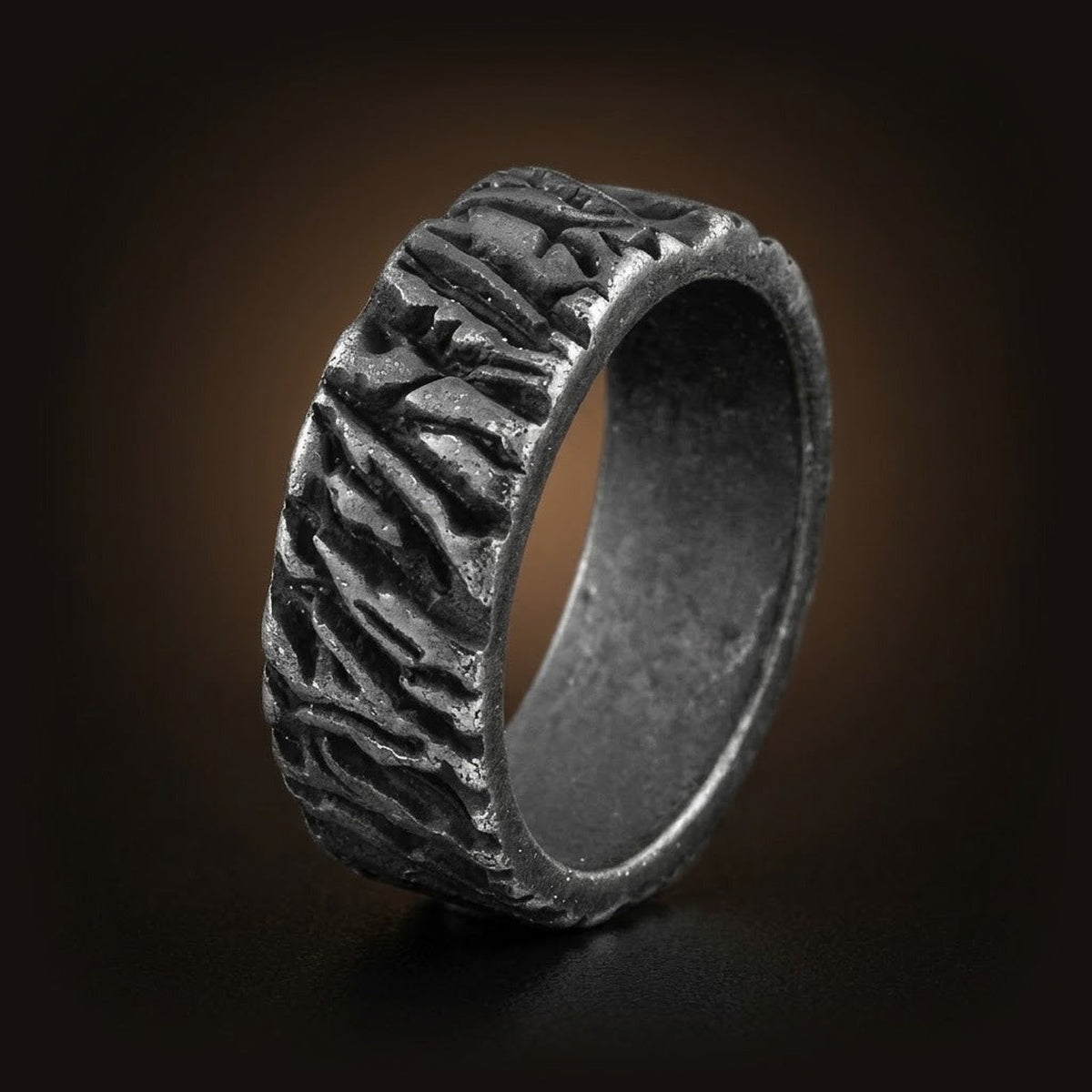 Bague viking en acier noirci, anneau à texture d'écorce et runes, sur fond noir