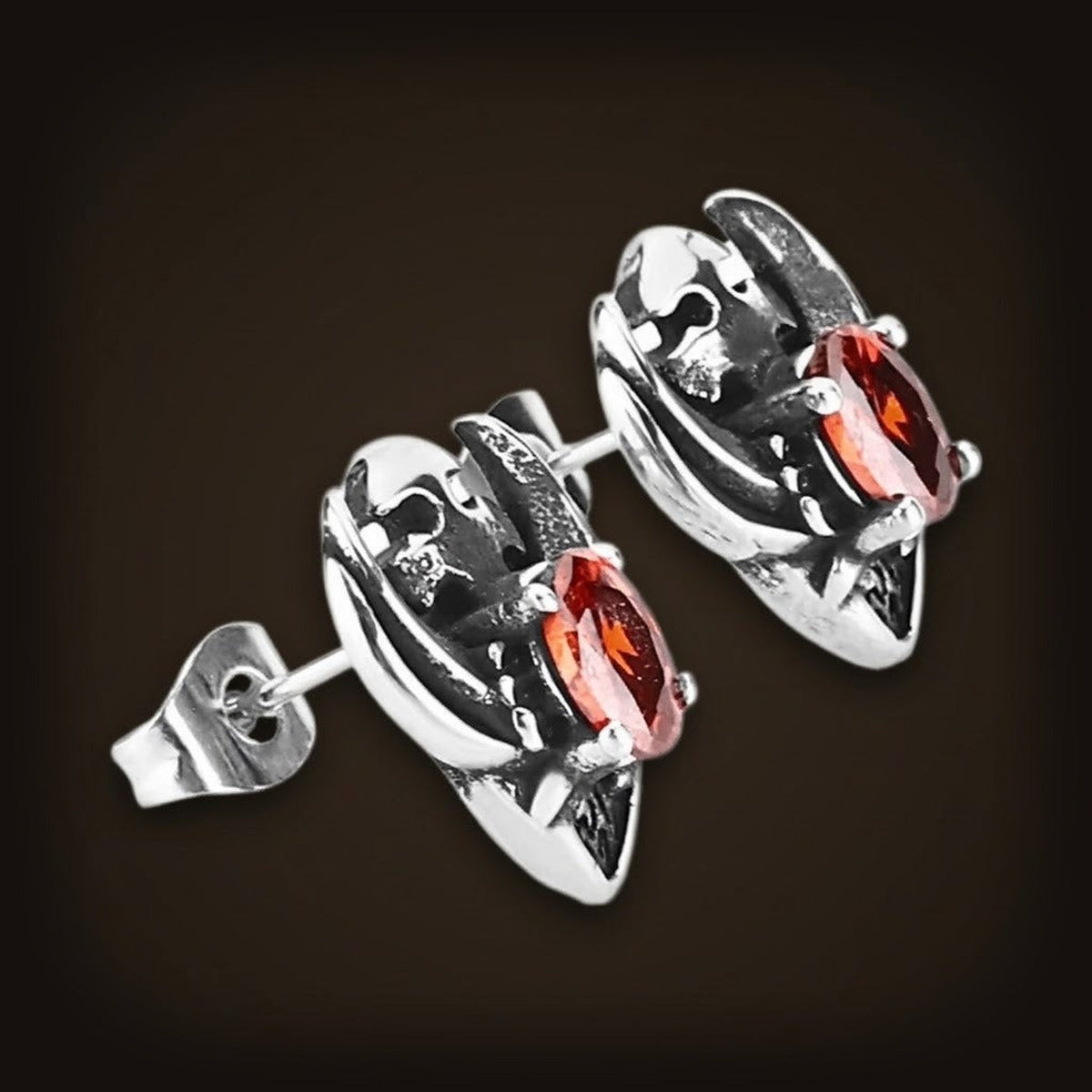 Puces d'oreilles en acier inoxydable, crâne gravé surmontant un zircon rouge ovale serti en biais