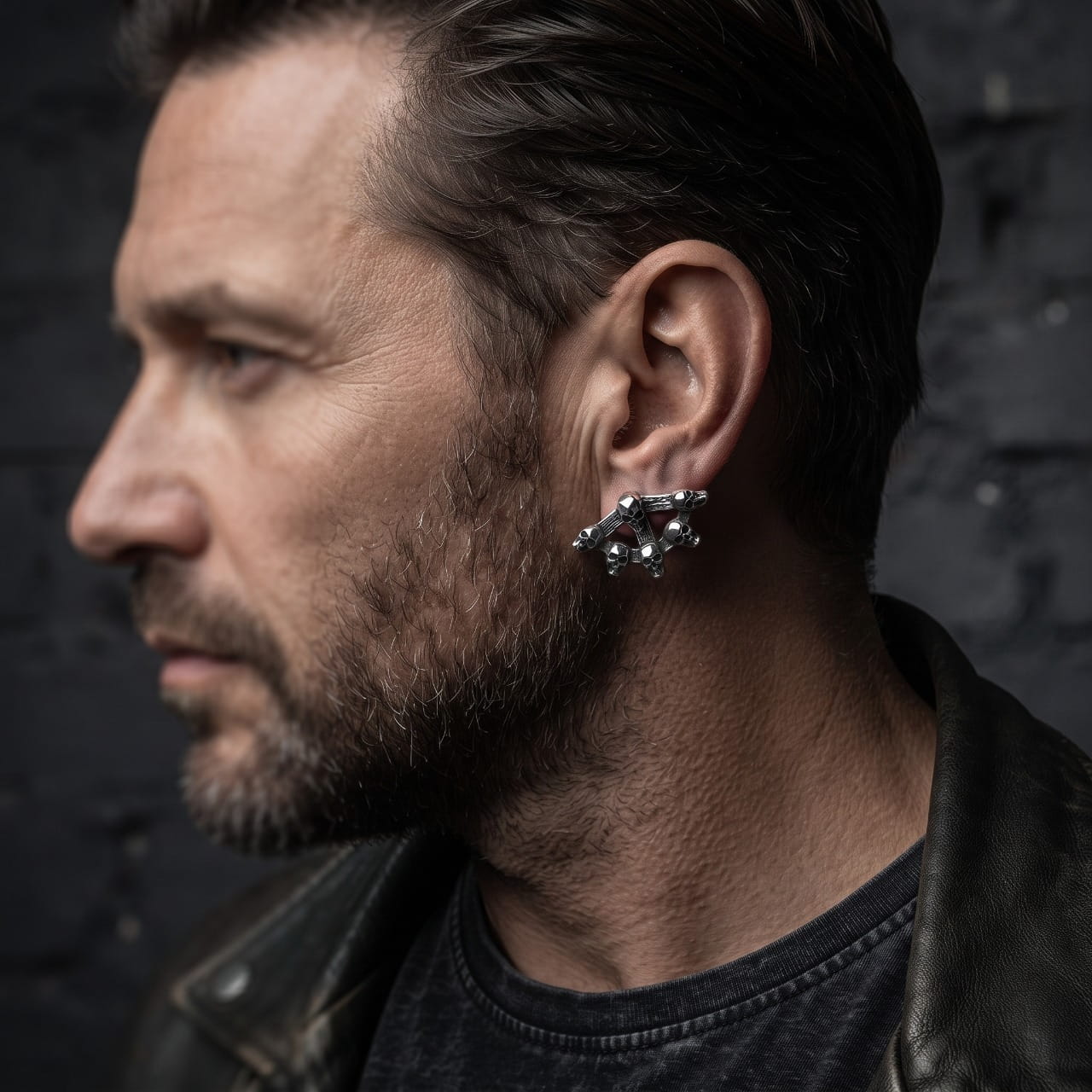 Boucle d'oreille crânes et os croisés en acier portée le long du lobe