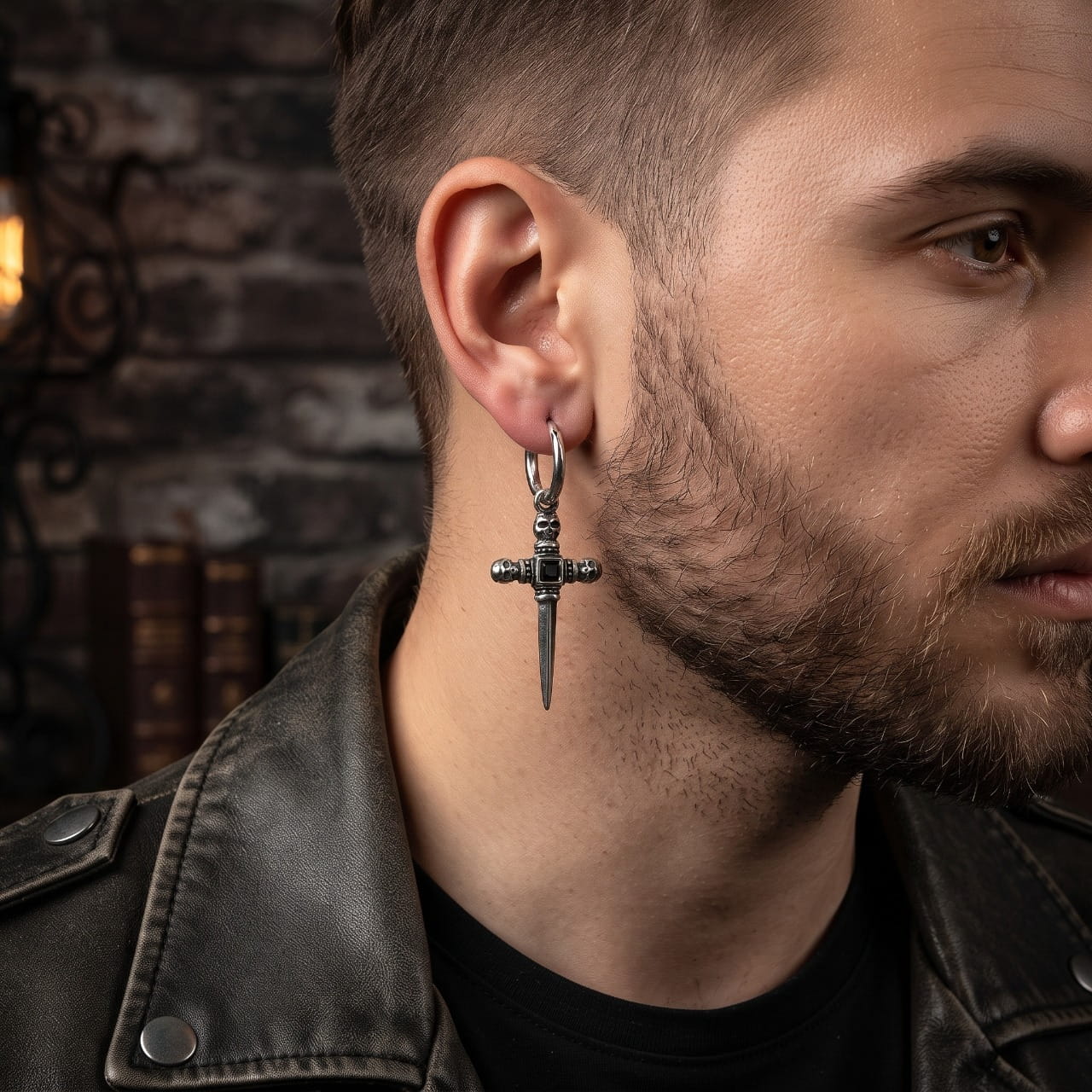 Pendante croix-épée en acier noirci sertie de zircons, portée à l'oreille