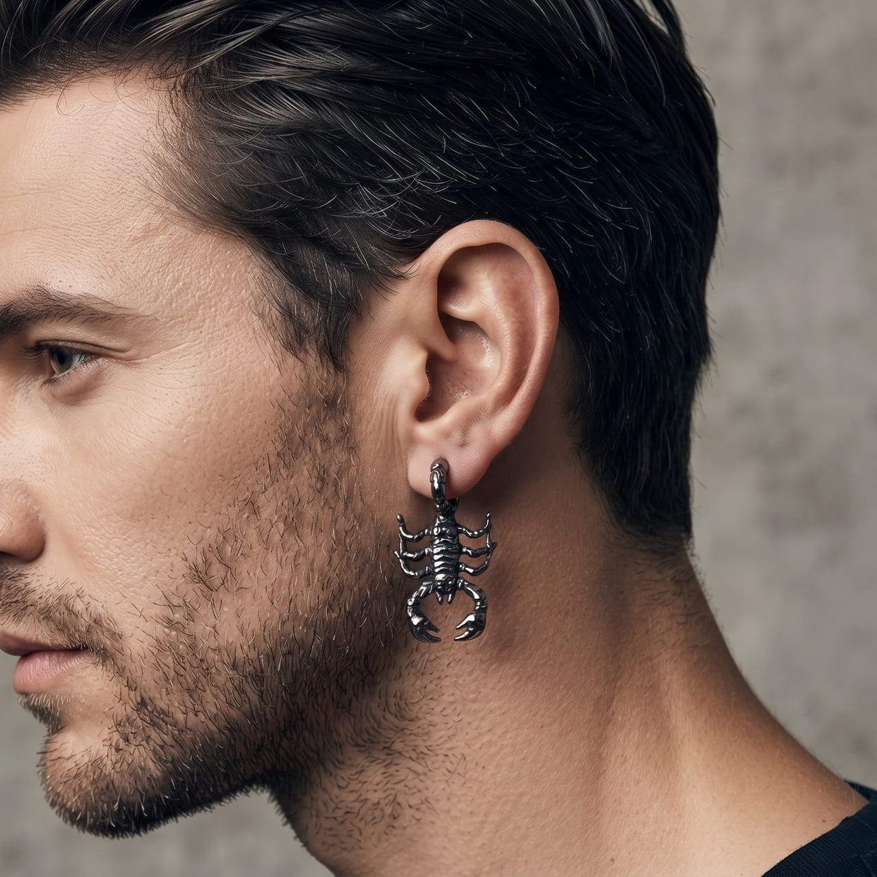 Boucle d'oreille scorpion en acier portée au lobe, queue relevée vers le haut