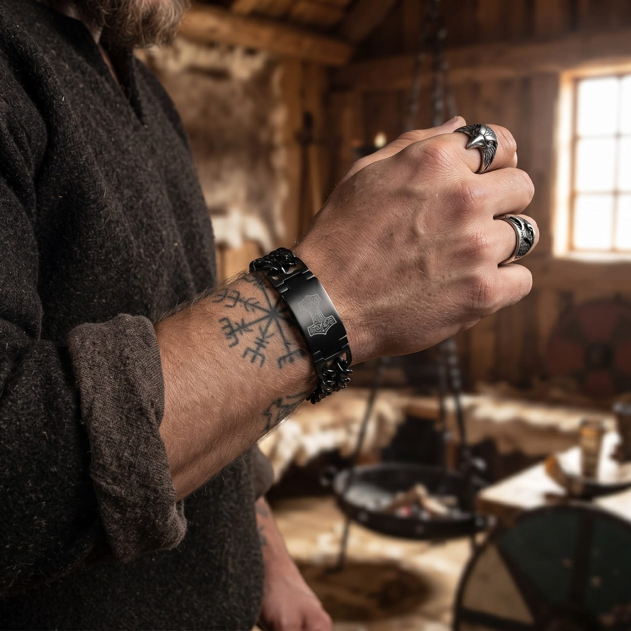 Bracelet viking à mailles d'acier sombre, porté au poignet dans une maison longue au feu allumé