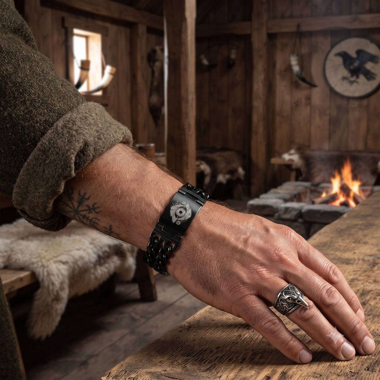 Bracelet viking à mailles tressées noires, porté au poignet, fourrures et bouclier en arrière-plan