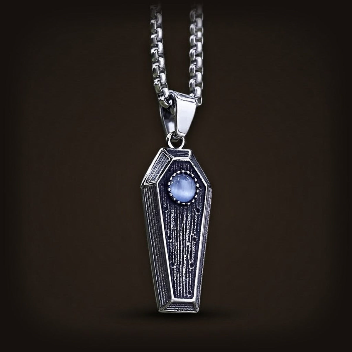 Pendentif cercueil en acier inoxydable au couvercle veiné façon bois, cabochon bleu et chaîne vénitienne