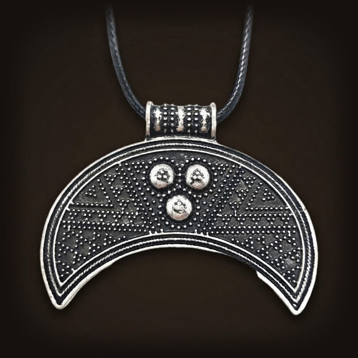 Pendentif lunule en croissant, décor granulé en chevrons et trois perles en triangle, finition argent vieilli