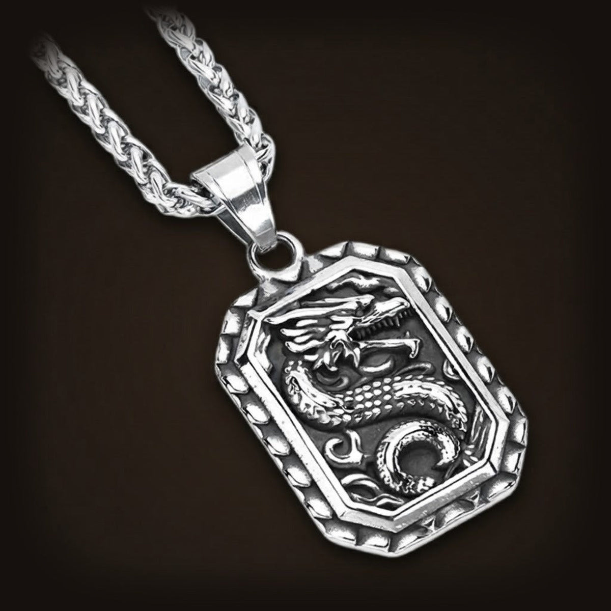 Pendentif dragon en acier, plaque octogonale au dragon lové, sur sa chaîne tressée