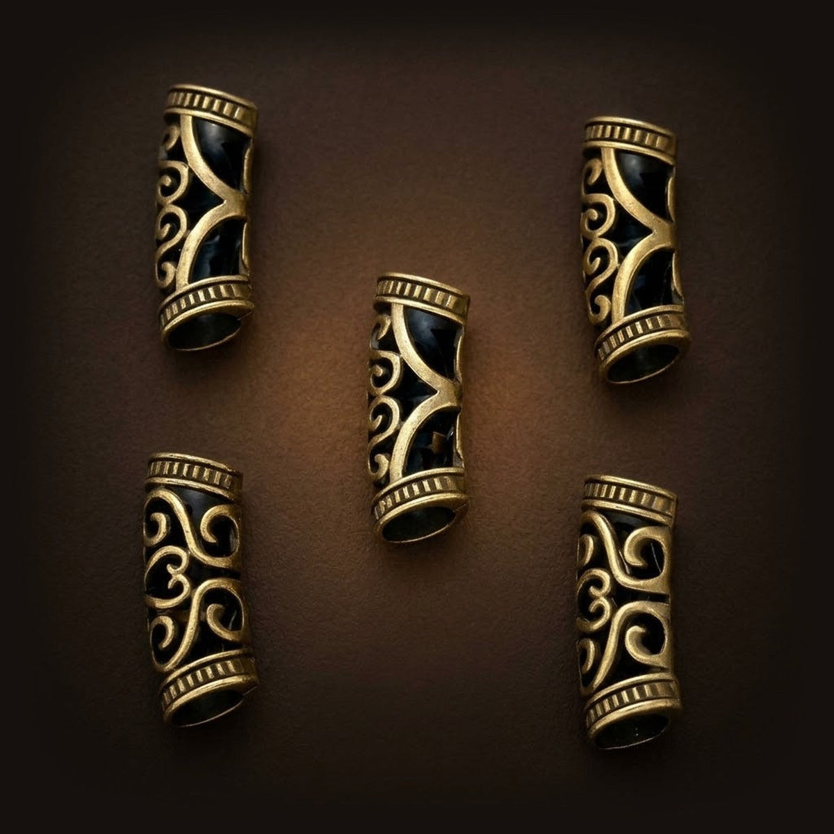 Lot de tubes de tresse vikings ajourés en alliage bronze patiné, motif de volutes découpé