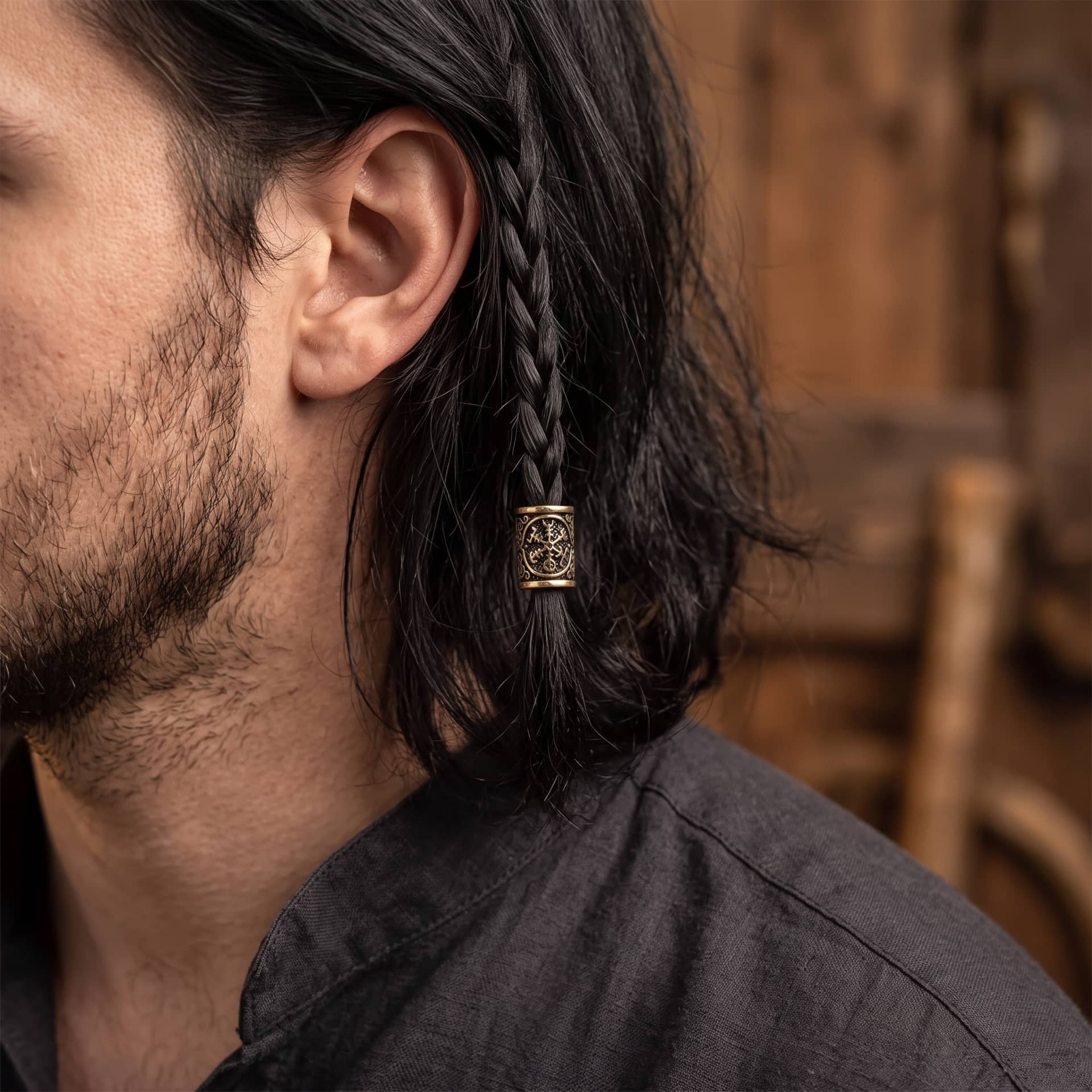 Perle viking en alliage bronze patiné, gravée de l'Ægishjálmur, aux huit bras identiques rayonnant d'un centre, portée sur une fine tresse de cheveux