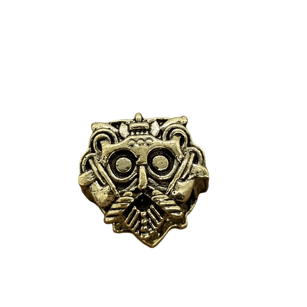 Perle viking en forme de masque, en alliage bronze patiné, masque barbu en relief, perçage traversant visible, sur fond blanc