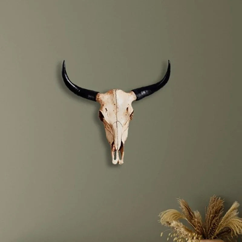 Crâne de taureau viking mural en résine, deux cornes noires arquées, accroché sur un mur clair